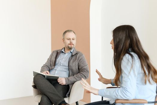 A male psychologist listens attentively to a female patient