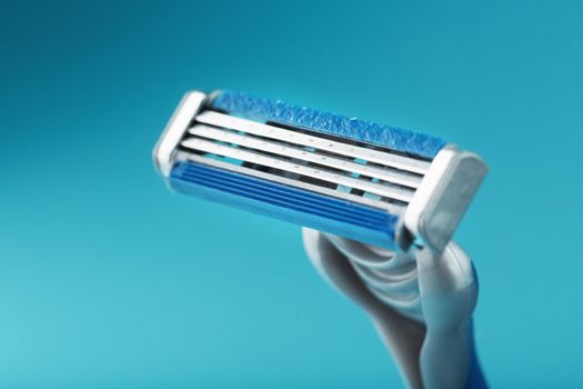 Three shaving machines on a blue background with free space, top view