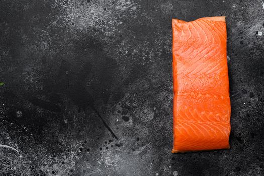 Raw Fillet of salmon set, on black dark stone table background, top view flat lay, with copy space for text