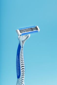 Blades of a new shaving machine on a blue background close-up free space