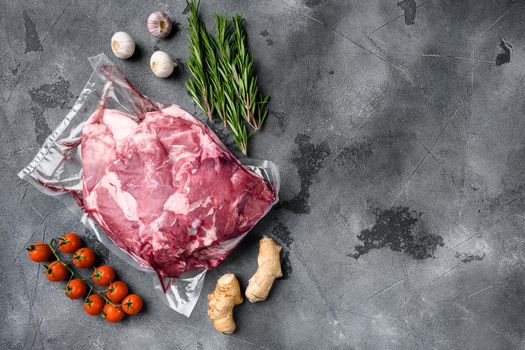 Lamb meat pack ready for cooking set, with ingredients and herbs, on gray stone table background, top view flat lay, with copy space for text