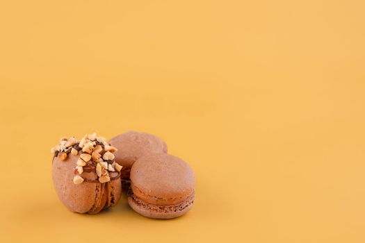 Several macaroons of various flavours on yellow background. Space for text