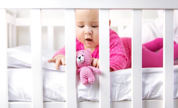 Baby toddler plays in the crib. Selective focus. Child.