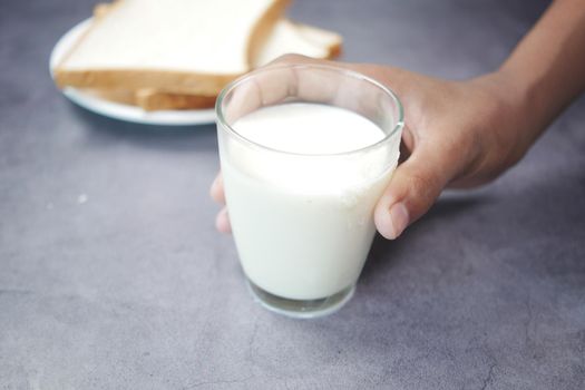 hand pick a glass of milk on black .