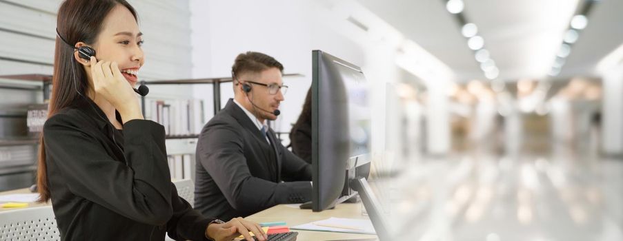 Business people wearing headset working in office to support remote customer or colleague. Call center, telemarketing, customer support agent provide service in broaden view .