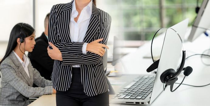 Business people wearing headset working in office to support remote customer or colleague. Call center, telemarketing, customer support agent provide service in broaden view .