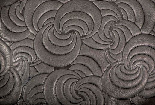 Texture of gray genuine leather with embossed floral trend pattern close-up, color, for wallpaper or banner design. Fashionable modern background