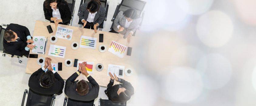 Successful business people celebrate together with joy at office table shot from top view . Young businessman and businesswoman workers express cheerful victory showing teamwork in broaden view .