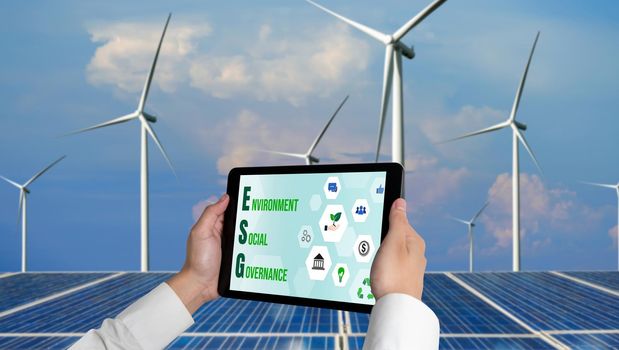 Green business transformation for environment saving and ESG business concept. Businessman using tablet to set corporate goal toward environmental friendly management and alternative clean energy use.