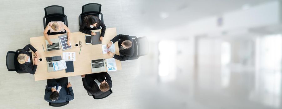 Business people group meeting shot from top widen view in office . Profession businesswomen, businessmen and office workers working in team conference with project planning document on meeting table .