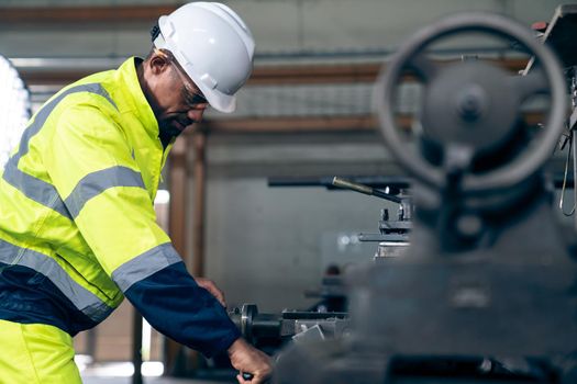 Factory worker or engineer do machine job in adept manufacturing workshop . Industrial people and manufacturing labor concept .