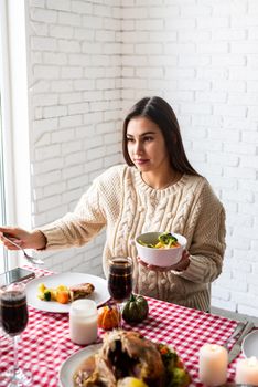 Happy Thanksgiving Day. Autumn feast. Woman celebrating holiday eating traditional dinner at kitchen with turkey, vegetables and pumpkin pie