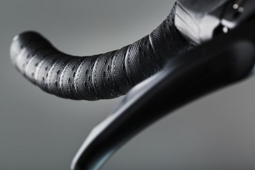 Steering wheel winding with brake handle of a road bike close-up on a gray background