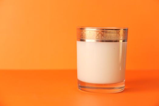 close up of bottle of milk on orange background .