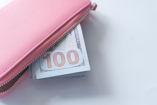 100 dollar cash in leather on pink background .