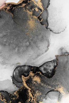 Black gold abstract background of marble liquid ink art painting on paper . Image of original artwork watercolor alcohol ink paint on high quality paper texture .