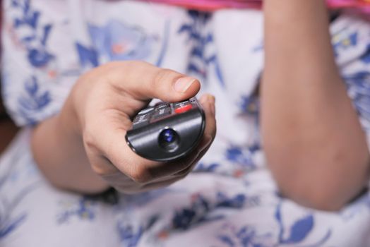 close up of women hand holding tv remote