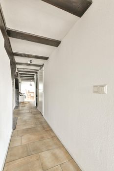 A compact light corridor with white walls and tiled floor