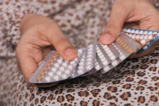 women hand golding birth control pills close up .