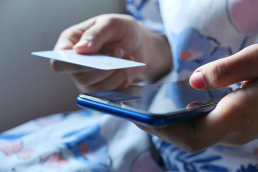 selective focus . women hand holding credit card and using smart phone shopping online.