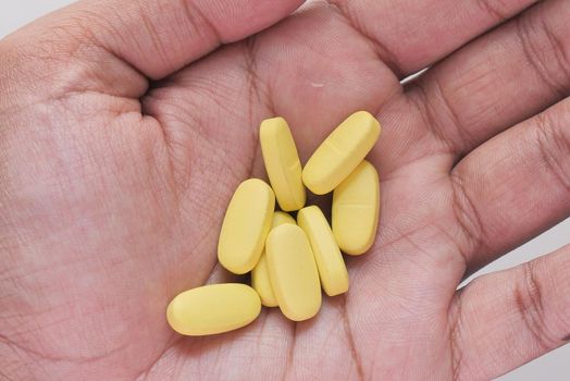 Close up of man hand taking medicine .