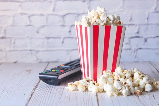popcorn in container and Tv remote on table ,