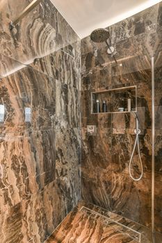 Spacious dark bathroom with shower and sink in a minimalist style