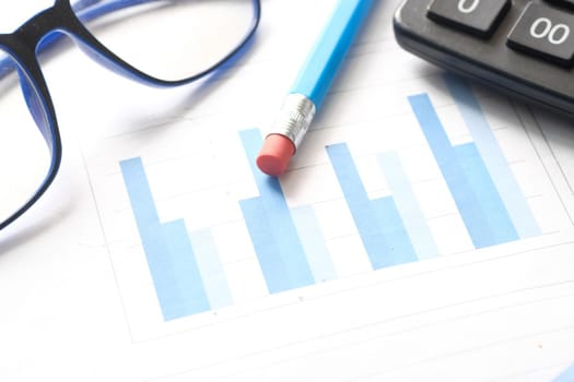 financial graph, calculator and notepad on table.