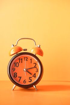 old alarm clock on orange background