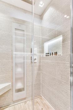 Sink base cabinet and mirror cabinet in white tiled bathroom with wall hung toilet