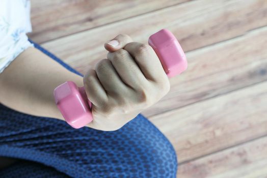 Young woman exercising with dumbbell weights