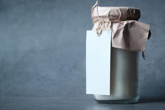 coconut oil in jar with a white label on black background..