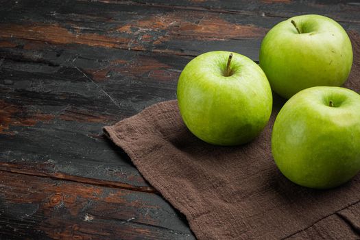 Several ripe green apples set, on old dark rustic table background, with copy space for text