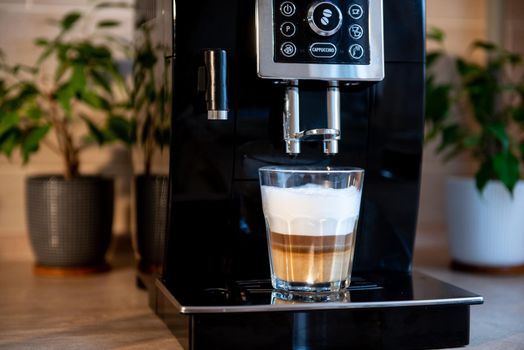 preparation of multi-layer cappuccino in a coffee machine. Coffee is poured into harvested foamed milk