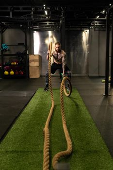 Rope man grass warehouse green fitness training gym exercising exercise, for athlete one from male from healthy moving, sport muscle. Standing ground holding, lifestyles