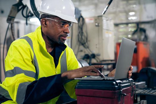 Factory worker working with laptop computer to do adept procedure checklist . Factory production line operator occupation quality control concept .