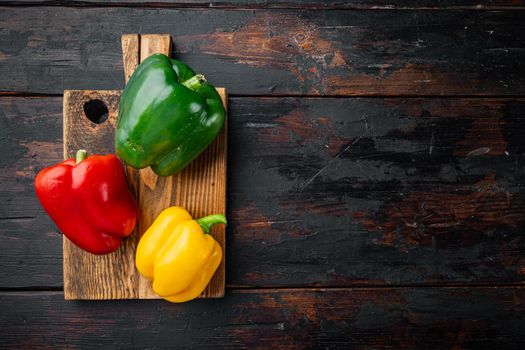 Sweet bell pepper, on old dark wooden table background, top view flat lay with copy space for text
