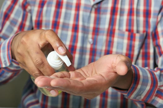close up of young man hand using sanitizer gel for preventing virus.