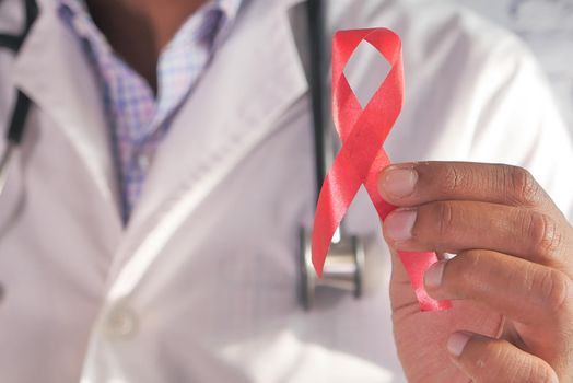 hand holding red HIV ribbon with copy space .