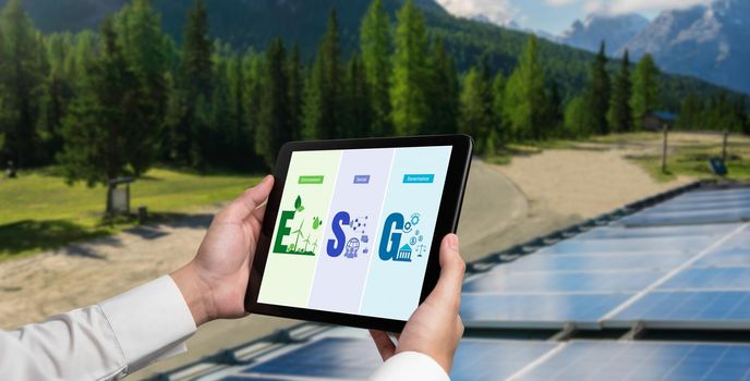 Green business transformation for environment saving and ESG business concept. Businessman using tablet to set corporate goal toward environmental friendly management and alternative clean energy use.