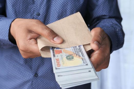 person hand putting cash in a envelope