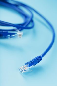 Blue Ethernet Cable Connectors Patch cord cord close-up isolated on a blue background with free space