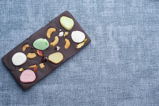 Nut candy in dark chocolate on table .