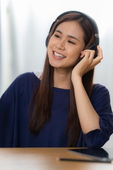 Portrait of Happy Asian artist woman using smart phone and listen music at home. Relax concept