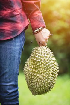 A woman holding Mon Thong durian fruit in her hand. Regarded by many people in southeast asia as the king of fruits.