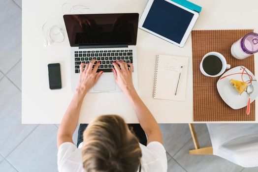 Businesswoman working from home using laptop.