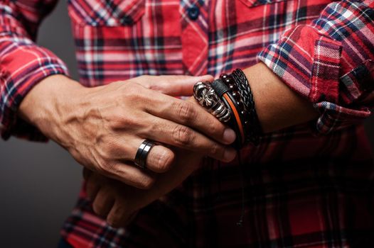 The man in red shirt wearing bracelets, casual style of men accessories. Shallow depth of field.