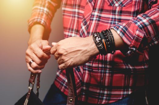 The man in red shirt wearing bracelets, casual style of men accessories. Shallow depth of field.