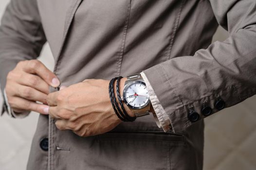 closeup the man's wrist wearing bracelets and wristwatch, casual style of men accessories.