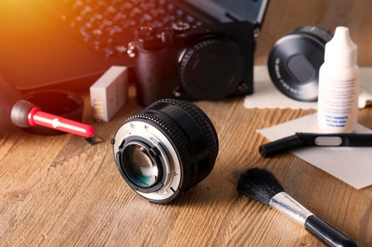 Camera and lens care. Camera cleaning kits and camera gears on photographer's desktop.